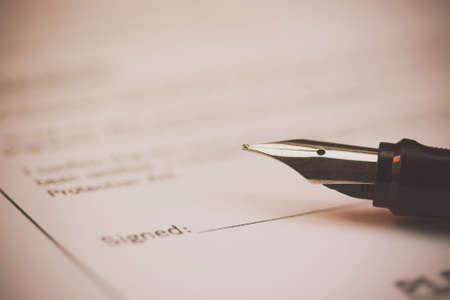 Close up of a fountain pen on a university application form. Retro filter applied.の写真素材
