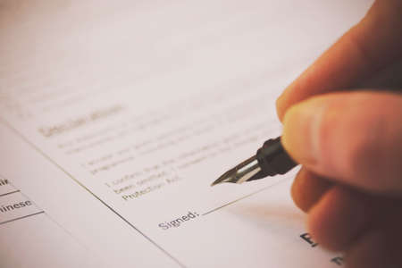 Close up of a fountain pen on a university application form. Retro filter applied.の写真素材