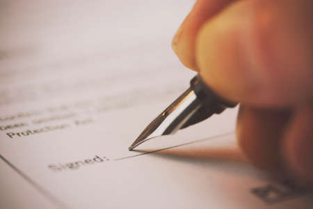 Close up of a fountain pen on a university application form. Retro filter applied.の写真素材