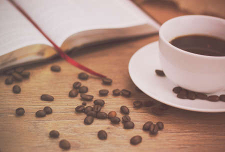 White coffee cup and saucer against a rustic background. Retro filter applied.の写真素材