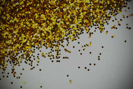 Close up of gold glitter shining in the light. Shollow depth of field. Vintage filter applied.の写真素材