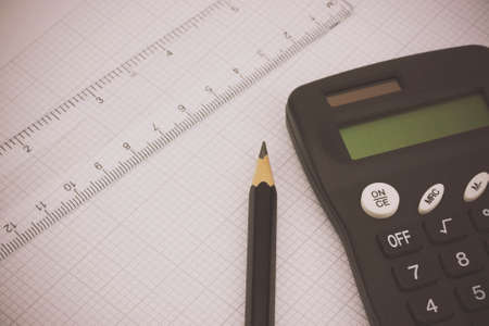 Close up of drawing equipment and calculator on graph paperの写真素材