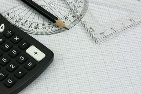 Close up of drawing equipment and calculator on graph paperの写真素材