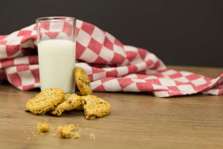 Homemade oat and raisin cookies with milk on a rustic backgroundの写真素材