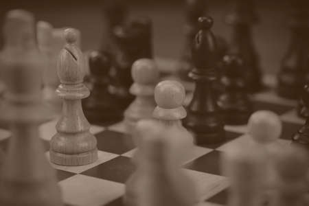 Wooden chess set with a game being played. Black and white filter applied.