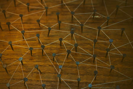 Rustic nails in wood linked together by cotton with a golden tint. Vintage filter applied.の写真素材