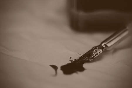 White feather quill pen with metal nib. Black and white filter appled.の写真素材