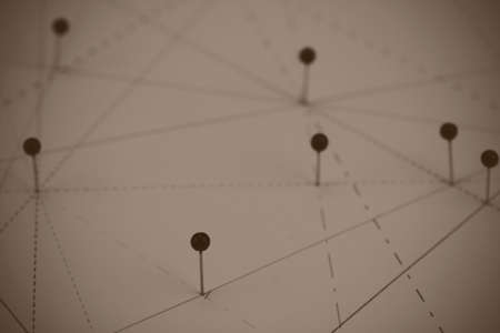 Black pins in paper linked together by lines
