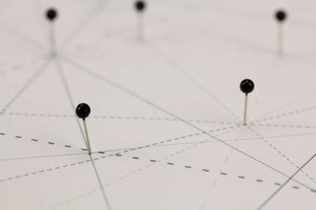 Black pins in paper linked together by linesの写真素材