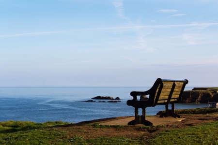 Empty bench over looking the coast in Bude, Cornwallの写真素材