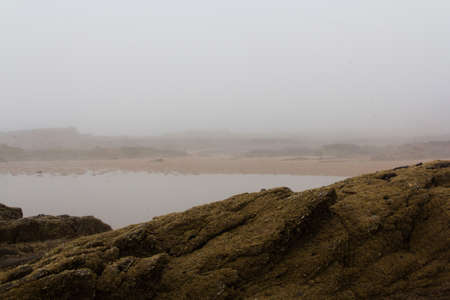 Rocks on the shore with sea mist in the background