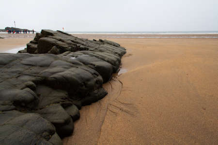 Wet sand and rocks on the beachの写真素材