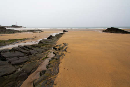 Wet sand and rocks on the beachの写真素材