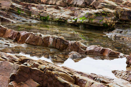 Water left stranded in the rocks by low tideの写真素材