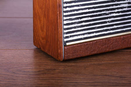 Old retro style radio on a wooden surface with light background