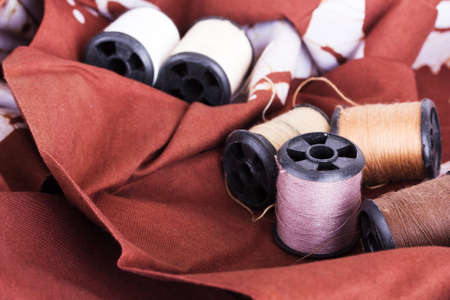 Reels of brown cotton for sewing on patterned material