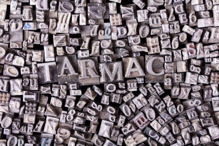 Close up of old used metal typeset letters with the word tarmacの写真素材