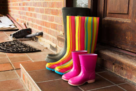 Colourful wellington boots left outside on a doorstepの写真素材