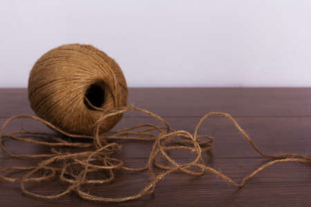 Ball of brown string on a wooden background