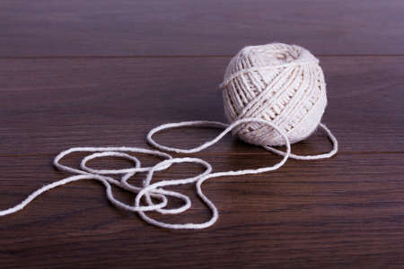 Ball of white string on a wooden backgroundの写真素材