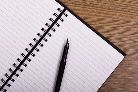 Lay flat image of an open notebook on a wooden surface