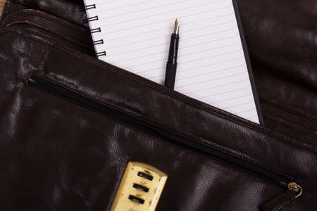 Notebook coming out of an open leather briefcase