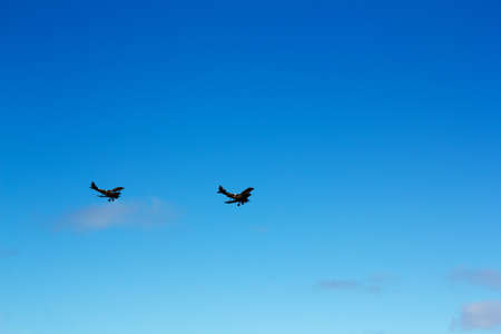 Pair of biplanes against a clear blue sky