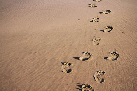 Footprints in the sand on Polzeath beach, Cornwall Vintage Retro Filter.の写真素材