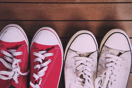 Old worn canvas shoes on a wooden floor Vintage Retro Filter.の写真素材