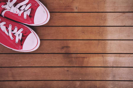Old worn canvas shoes on a wooden floor Vintage Retro Filter.の写真素材