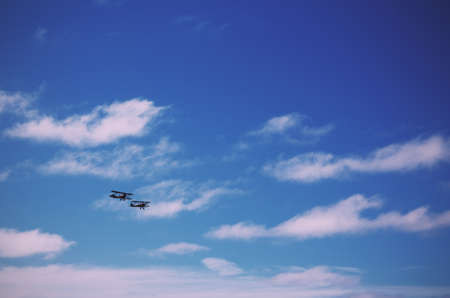 Pair of biplanes against a clear blue sky Vintage Retro Filter.