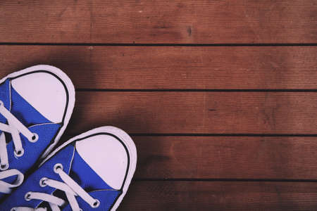 Old worn canvas shoes on a wooden floor Vintage Retro Filter.の写真素材