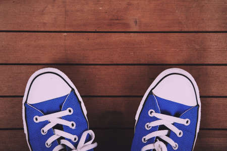 Old worn canvas shoes on a wooden floor Vintage Retro Filter.の写真素材