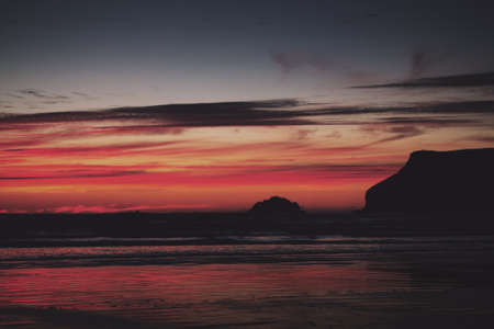 Colourful sunset over the beach at Polzeath, Cornwall Vintage Retro Filter.の写真素材