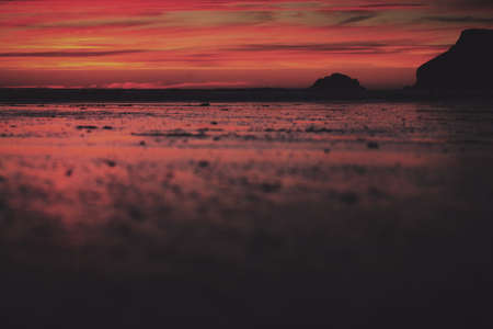 Colourful sunset over the beach at Polzeath, Cornwall Vintage Retro Filter.
