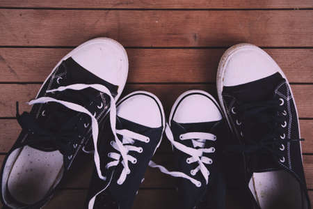 Old worn canvas shoes on a wooden floor Vintage Retro Filter.の写真素材