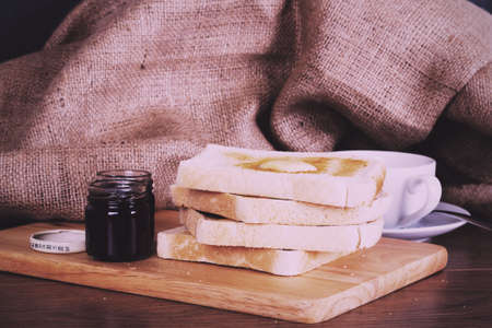 Slices of warm toast against a rustic wooden background Vintage Retro Filter.の写真素材