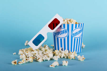 Bucket of popcorn against a blue backgroundの写真素材