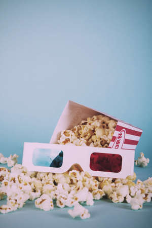 Bucket of popcorn against a blue background Vintage Retro Filter.の写真素材
