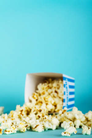 Bucket of popcorn against a blue backgroundの写真素材