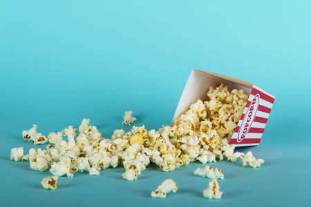 Bucket of popcorn against a blue backgroundの写真素材