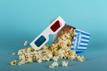 Bucket of popcorn against a blue backgroundの写真素材