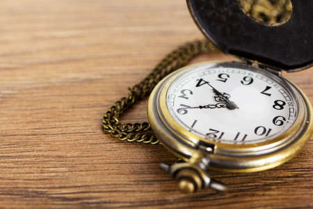 Pocket watch against a rustic wooden backgroundの写真素材