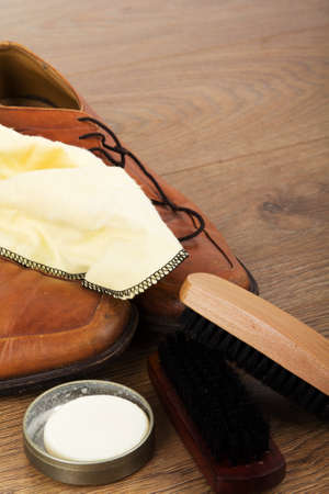 Shoes and cleaning equipment on a rustic wooden floorの写真素材
