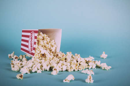 Bucket of popcorn against a blue background Vintage Retro Filter.