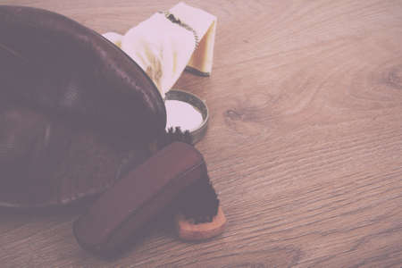 Shoes and cleaning equipment on a rustic wooden floor Vintage Retro Filter.の写真素材