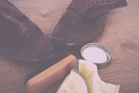 Shoes and cleaning equipment on a rustic wooden floor Vintage Retro Filter.