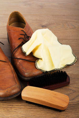 Shoes and cleaning equipment on a rustic wooden floorの写真素材