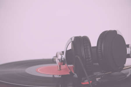 Black headphones on an old retro record player Vintage Retro Filter.の写真素材