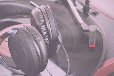 Black headphones on an old retro record player Vintage Retro Filter.の写真素材